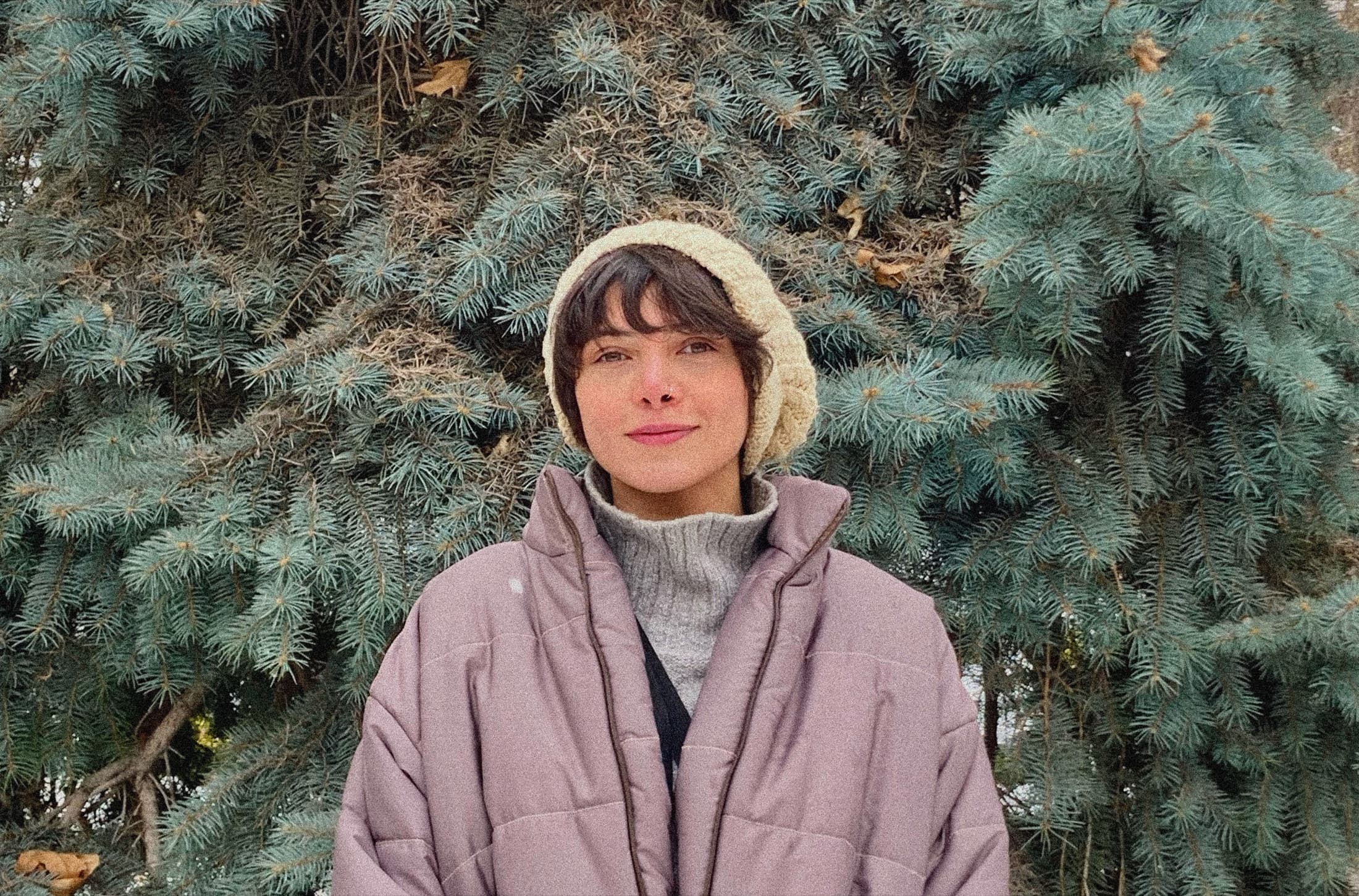 Paeez Mousavi outdoors in front of a blue spruce.